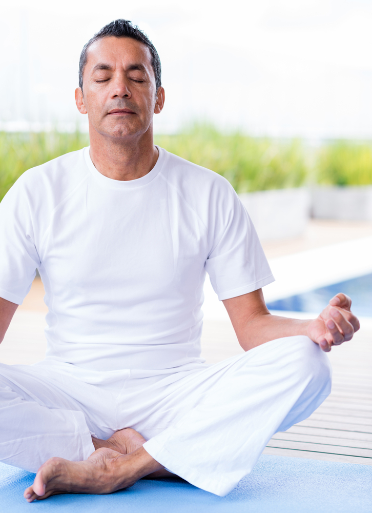 Man practicing yoga sitting with his eyes closed